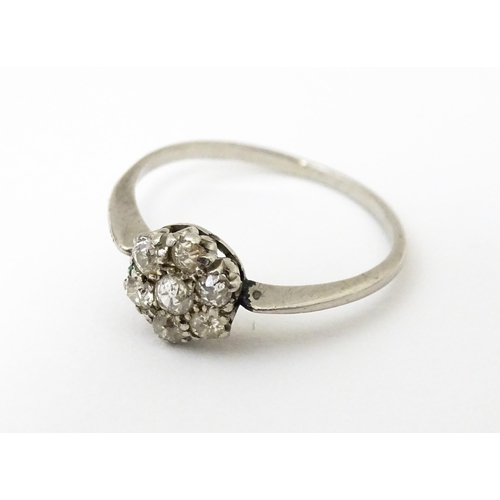 630 - A platinum ring set with six diamonds in a daisy setting. Setting approx. 1/4