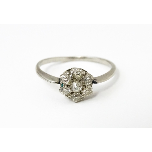 630 - A platinum ring set with six diamonds in a daisy setting. Setting approx. 1/4