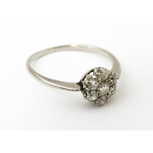 630 - A platinum ring set with six diamonds in a daisy setting. Setting approx. 1/4