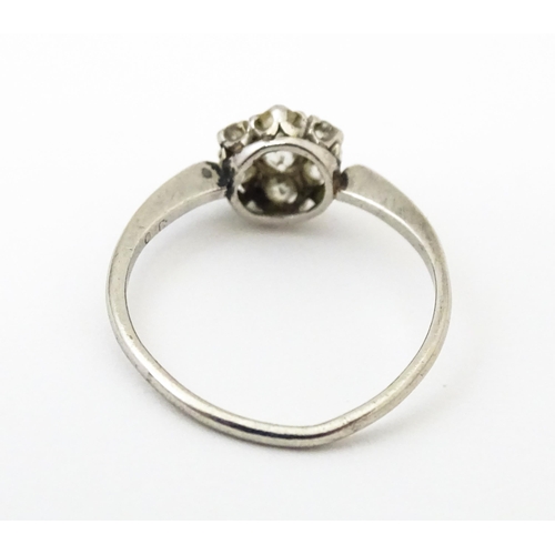 630 - A platinum ring set with six diamonds in a daisy setting. Setting approx. 1/4