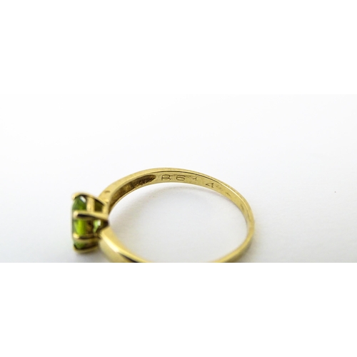 634 - A 9ct gold ring set with central peridot. Ring size approx. L