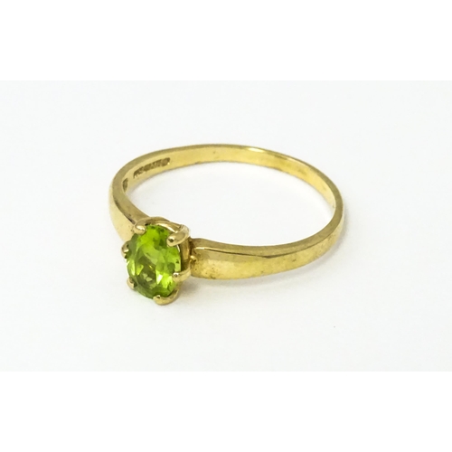 634 - A 9ct gold ring set with central peridot. Ring size approx. L