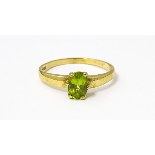 634 - A 9ct gold ring set with central peridot. Ring size approx. L