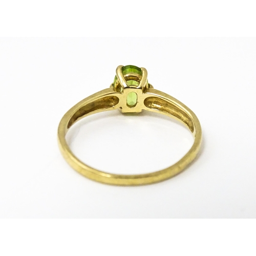 634 - A 9ct gold ring set with central peridot. Ring size approx. L