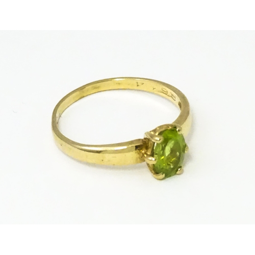 634 - A 9ct gold ring set with central peridot. Ring size approx. L