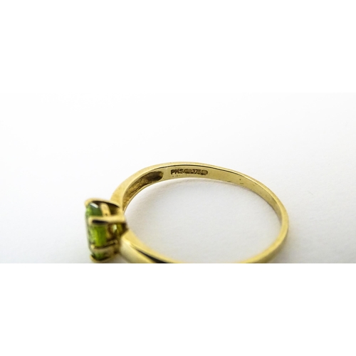 634 - A 9ct gold ring set with central peridot. Ring size approx. L