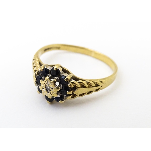 639 - A 9ct gold ring set with central diamond bordered by sapphires. Ring size approx. M