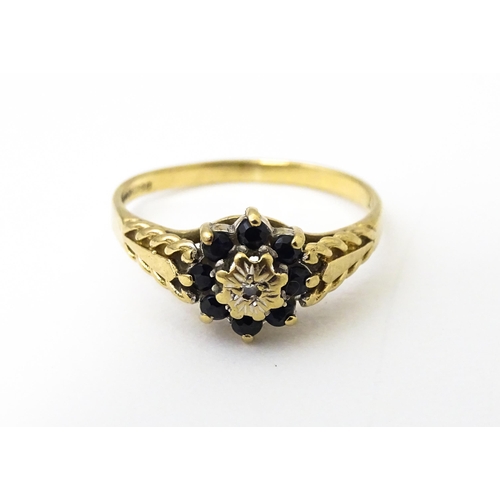 639 - A 9ct gold ring set with central diamond bordered by sapphires. Ring size approx. M