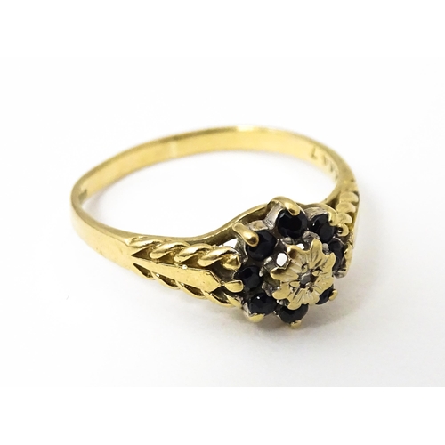 639 - A 9ct gold ring set with central diamond bordered by sapphires. Ring size approx. M