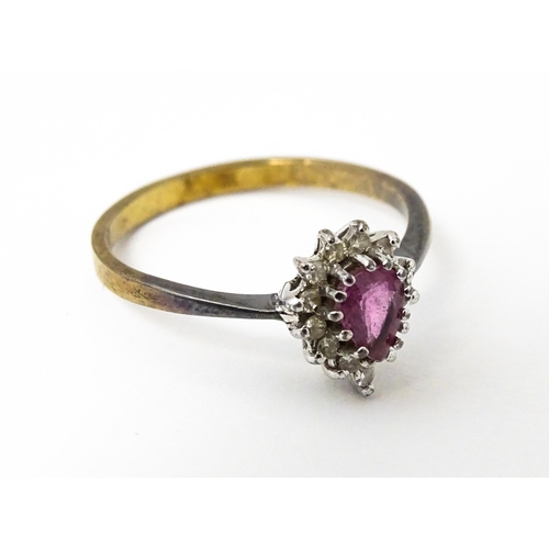 640 - A yellow metal ring set with pink sapphire flanked by diamonds. Ring size approx. M