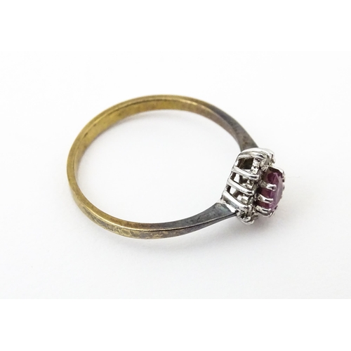 640 - A yellow metal ring set with pink sapphire flanked by diamonds. Ring size approx. M