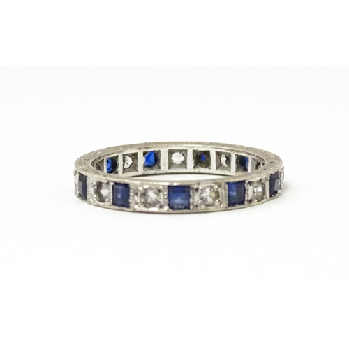 648 - A 9ct gold eternity ring set with sapphires and white stones. Ring size approx. M 1/2