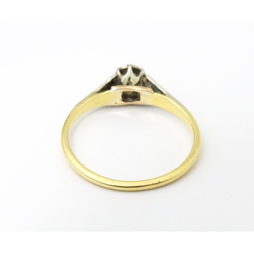 652 - An 18ct gold ring with platinum set diamond. Ring size approx. M