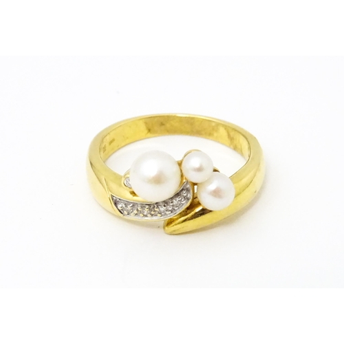 653 - An 18ct gold ring set with diamonds and pearls. Ring size approx. N 1/2