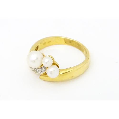 653 - An 18ct gold ring set with diamonds and pearls. Ring size approx. N 1/2