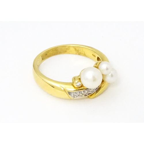 653 - An 18ct gold ring set with diamonds and pearls. Ring size approx. N 1/2