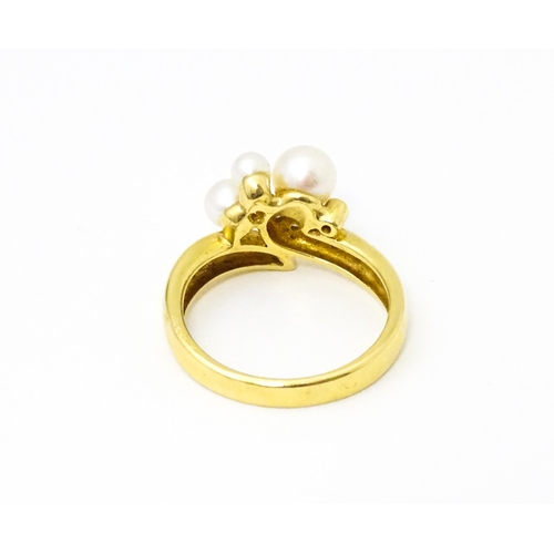 653 - An 18ct gold ring set with diamonds and pearls. Ring size approx. N 1/2