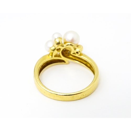 653 - An 18ct gold ring set with diamonds and pearls. Ring size approx. N 1/2