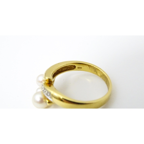 653 - An 18ct gold ring set with diamonds and pearls. Ring size approx. N 1/2