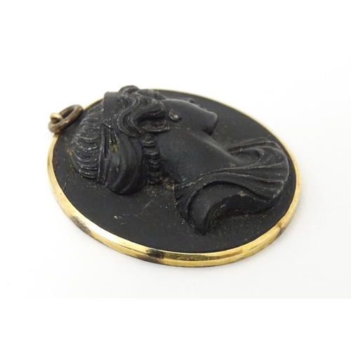 674 - A Victorian black lava cameo pendant in yellow metal mount. Approx 1 1/42 long