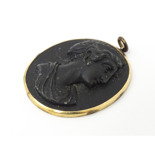 674 - A Victorian black lava cameo pendant in yellow metal mount. Approx 1 1/42 long