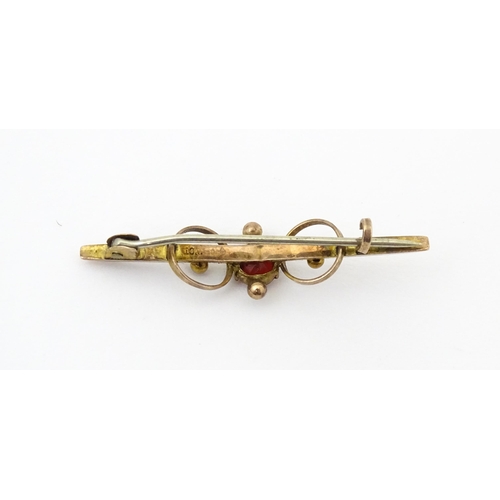 676 - A 9ct gold bar brooch set with red stone. 1 3/4