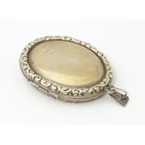 677 - A white metal pendant of locket form with engrave decoration. Approx 1 1/5