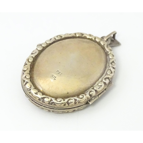 677 - A white metal pendant of locket form with engrave decoration. Approx 1 1/5