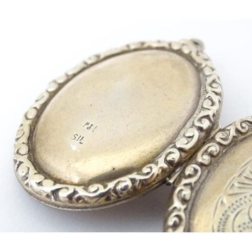 677 - A white metal pendant of locket form with engrave decoration. Approx 1 1/5