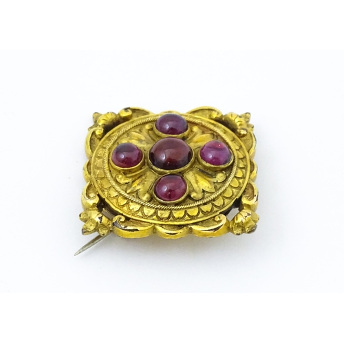 682 - A Victorian yellow metal brooch set with five garnet cabochon , approx 1 3/4