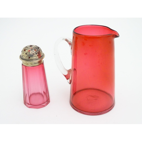 282 - A cranberry glass sugar shaker with a silver lid hallmarked London 1906. Together with a cranberry g... 