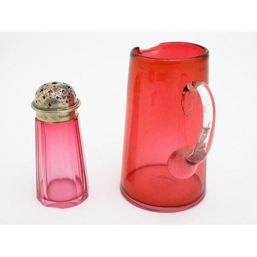 282 - A cranberry glass sugar shaker with a silver lid hallmarked London 1906. Together with a cranberry g... 