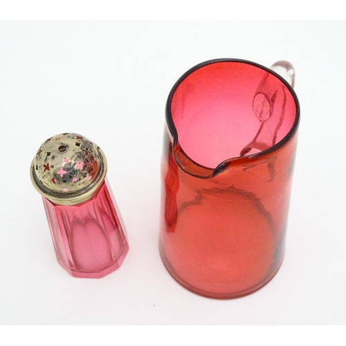 282 - A cranberry glass sugar shaker with a silver lid hallmarked London 1906. Together with a cranberry g... 