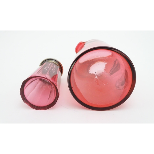 282 - A cranberry glass sugar shaker with a silver lid hallmarked London 1906. Together with a cranberry g... 