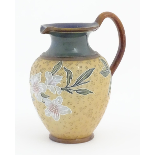 102 - A Doulton Lambeth Art Union of London stoneware jug decorated with flowers and foliage in relief. Im... 