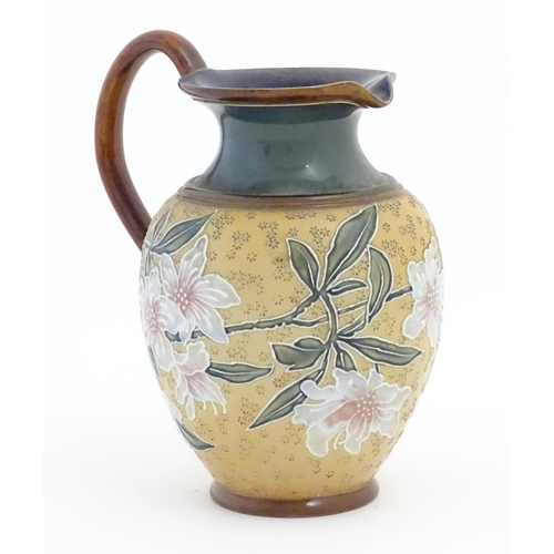 102 - A Doulton Lambeth Art Union of London stoneware jug decorated with flowers and foliage in relief. Im... 