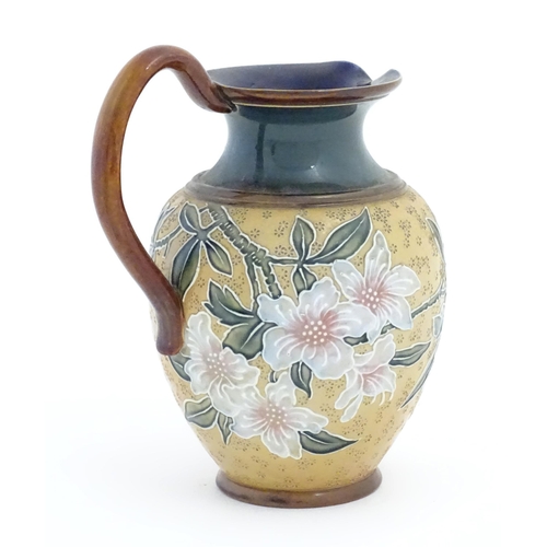 102 - A Doulton Lambeth Art Union of London stoneware jug decorated with flowers and foliage in relief. Im... 