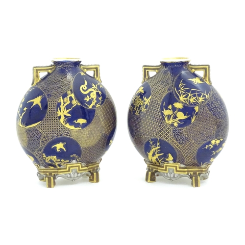 112 - Two Royal Worcester Aesthetic Movement moon flask vases with twin gilt handles and raised feet, the ... 