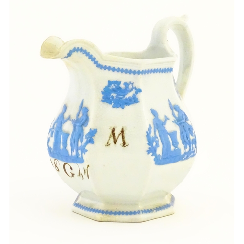 115 - A Victorian marriage jug, the cream ground decorated in blue relief depicting figures, Classical urn... 