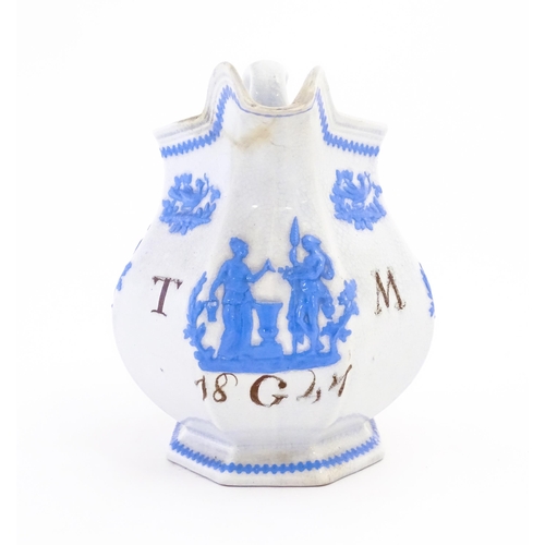 115 - A Victorian marriage jug, the cream ground decorated in blue relief depicting figures, Classical urn... 