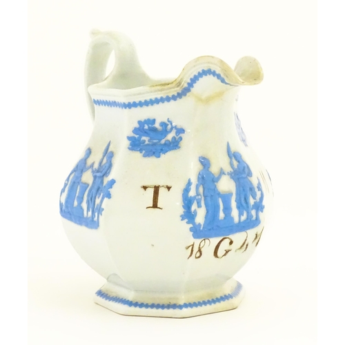 115 - A Victorian marriage jug, the cream ground decorated in blue relief depicting figures, Classical urn... 