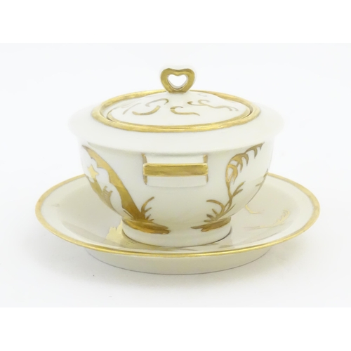 125A - A French Theo Haviland consomme pot with saucer, decorated with gilt chinoiserie detail. Marked unde... 