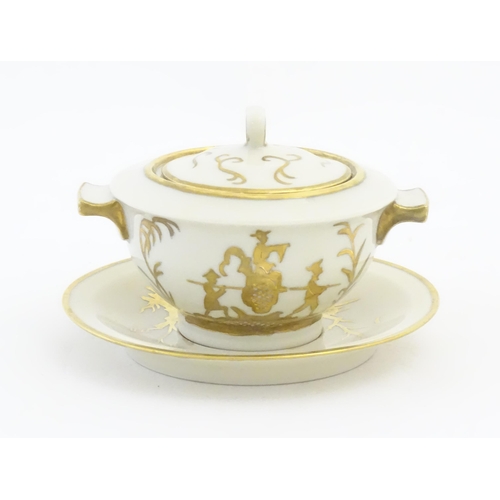 125A - A French Theo Haviland consomme pot with saucer, decorated with gilt chinoiserie detail. Marked unde... 