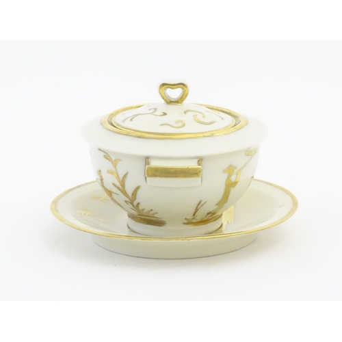 125A - A French Theo Haviland consomme pot with saucer, decorated with gilt chinoiserie detail. Marked unde... 