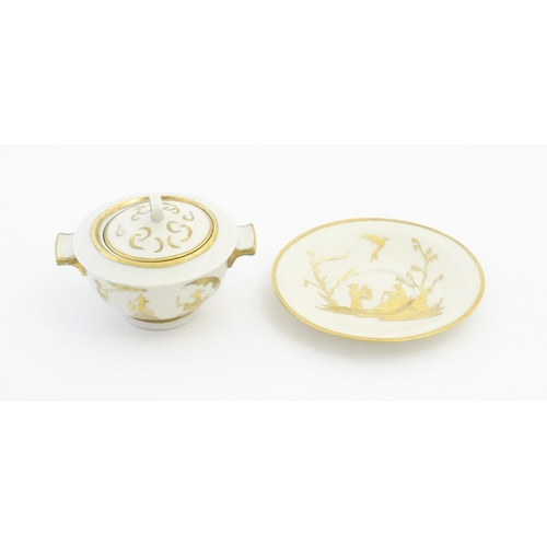 125A - A French Theo Haviland consomme pot with saucer, decorated with gilt chinoiserie detail. Marked unde... 