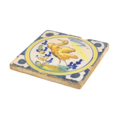 130 - A Continental Delft style tile depicting a bird within a roundel, with shaped detail to corners. App... 