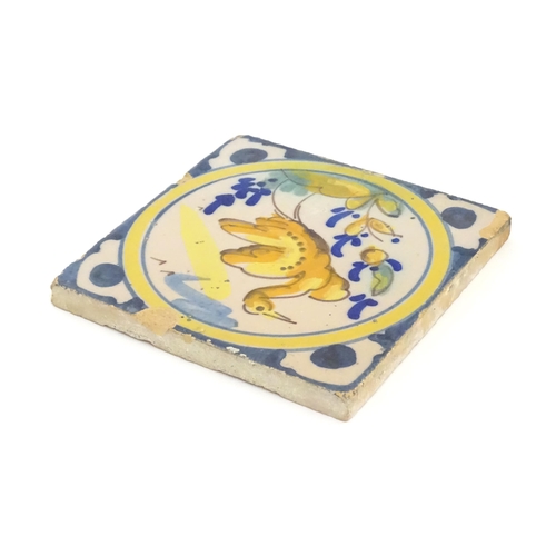 130 - A Continental Delft style tile depicting a bird within a roundel, with shaped detail to corners. App... 