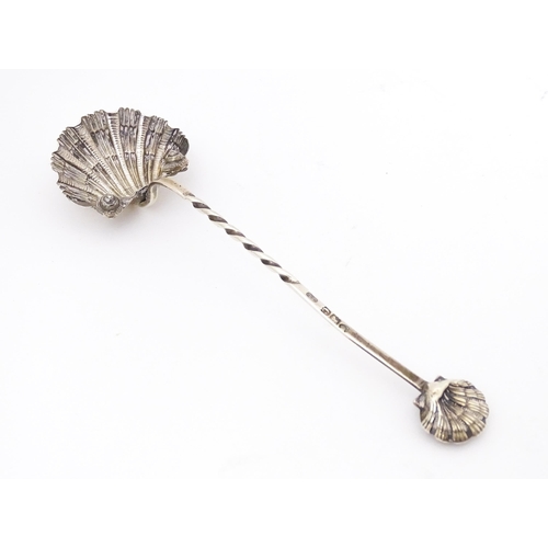 323 - A Victorian silver preserve / sugar spoon with scallop shell formed bowl and handle finial. Hallmark... 