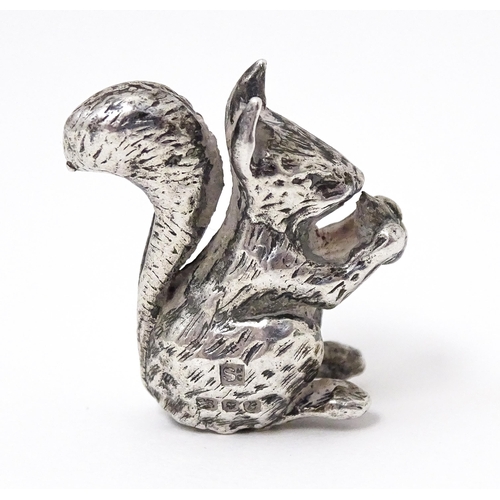 327 - A miniature silver model of a seated squirrel with a nut, hallmarked London 1976. Approx. 1