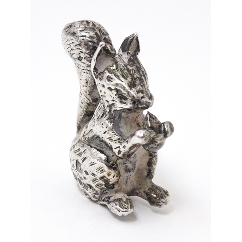 327 - A miniature silver model of a seated squirrel with a nut, hallmarked London 1976. Approx. 1